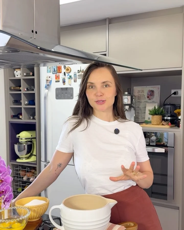 Tálita de camiseta branca junto aos ingredientes e tigelas da receita de bolo formigueiro