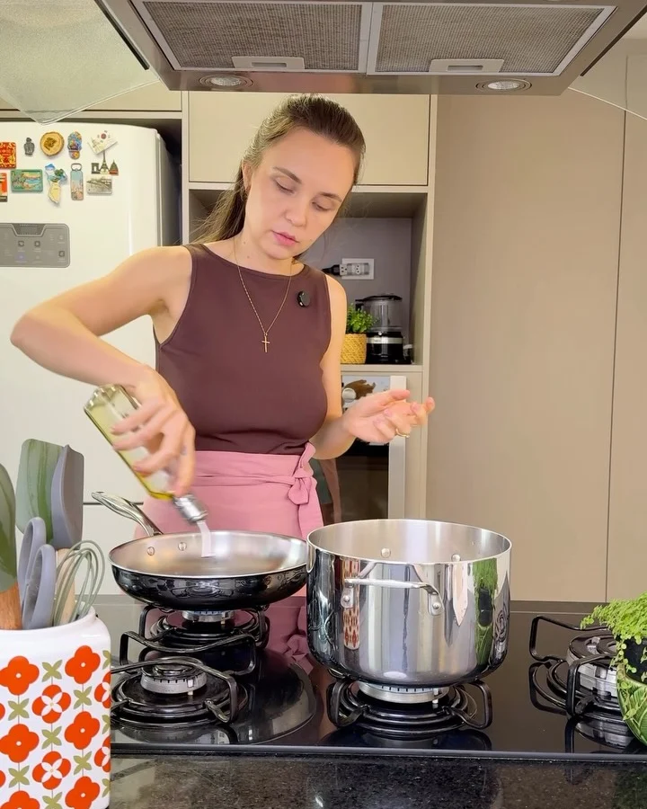 Tálita temperando a frigideira durante o preparo de tiras de carne